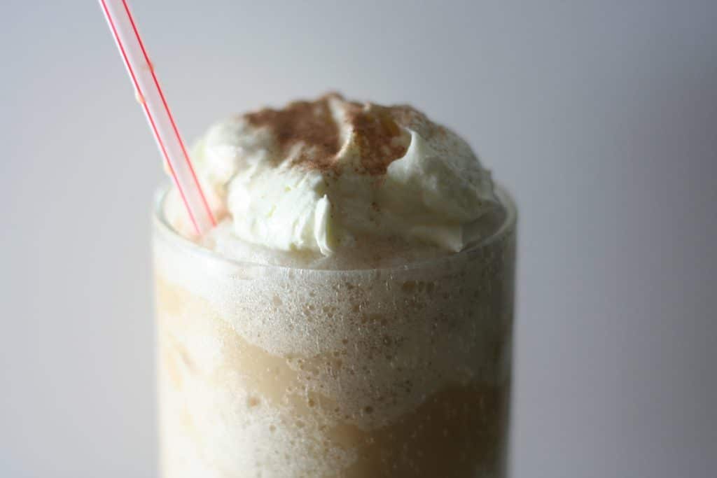 Iced coffee cocktail or frappe with ice cubes and cream in