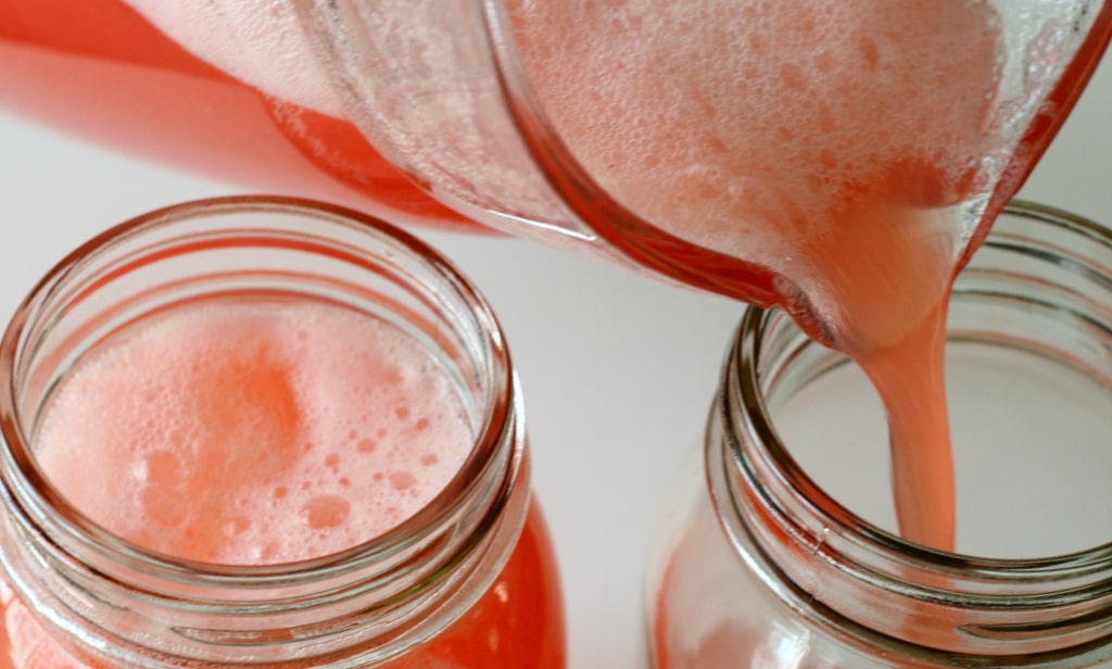 Strawberry lemonade being poured into glasses