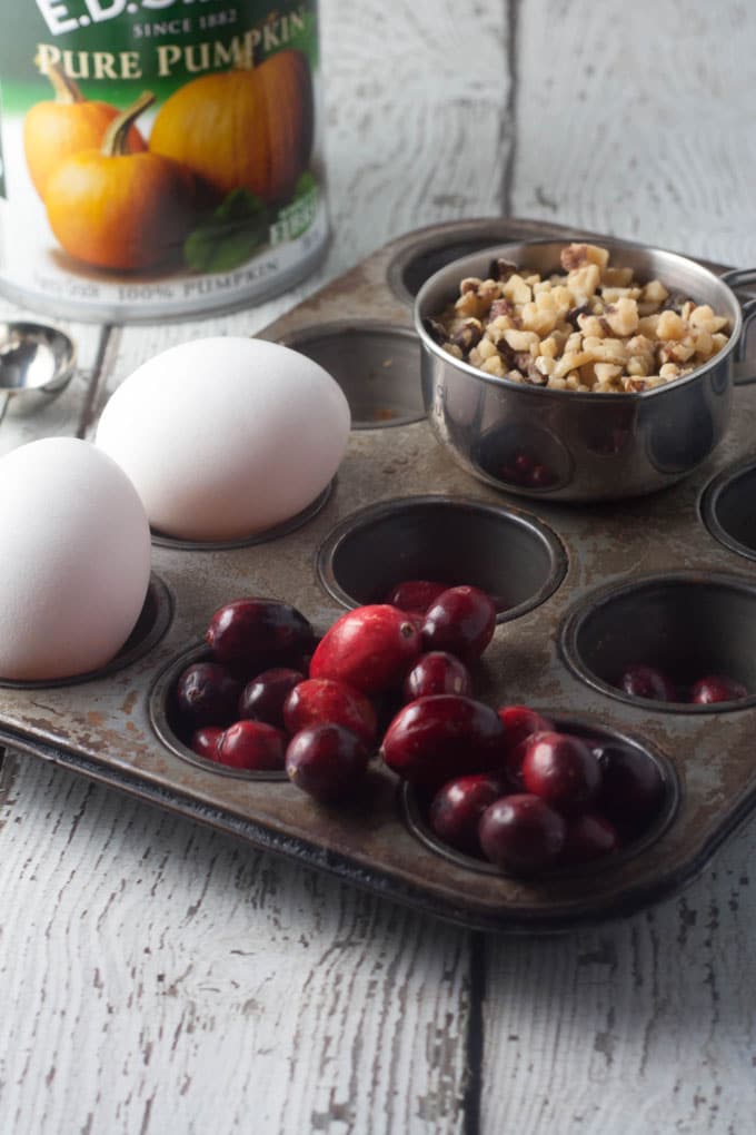 eggs, fresh cranberries and walnuts in a muffin tin