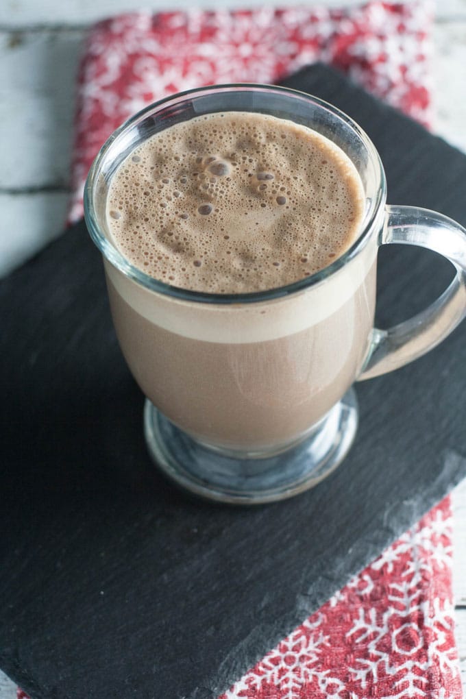 Mug with hot beverage served on slate board.