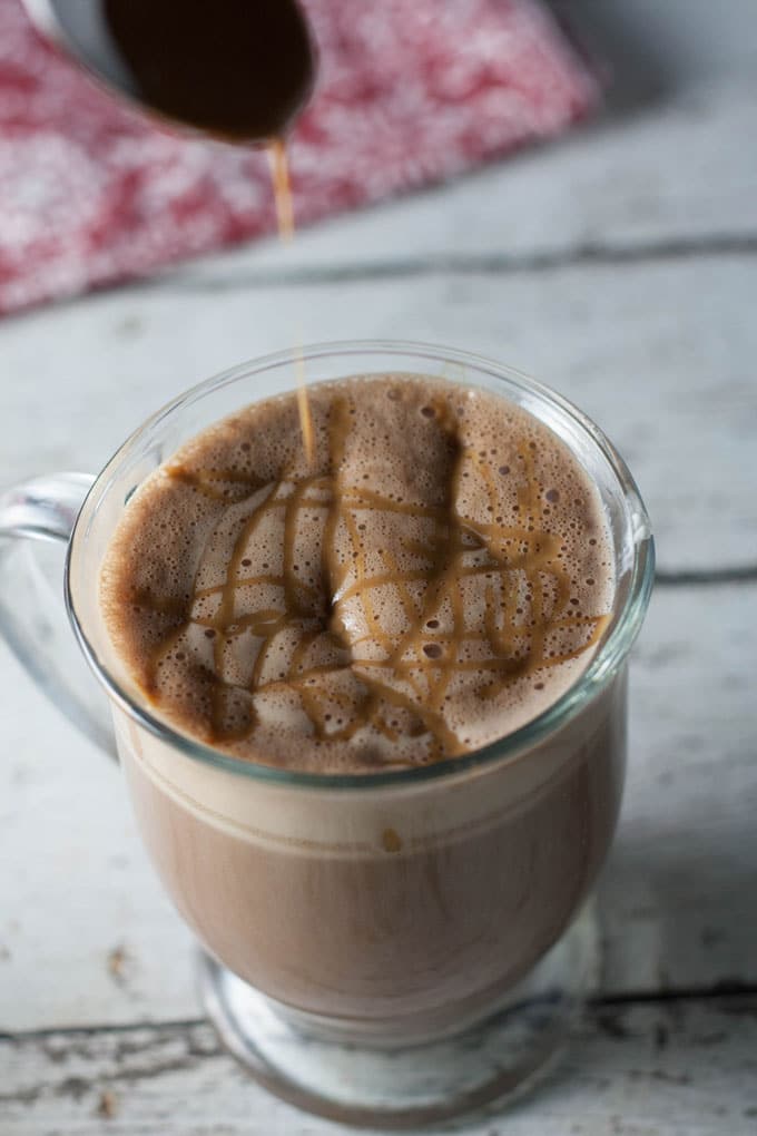 Drizzle being spooned on hot beverage served in a mug.