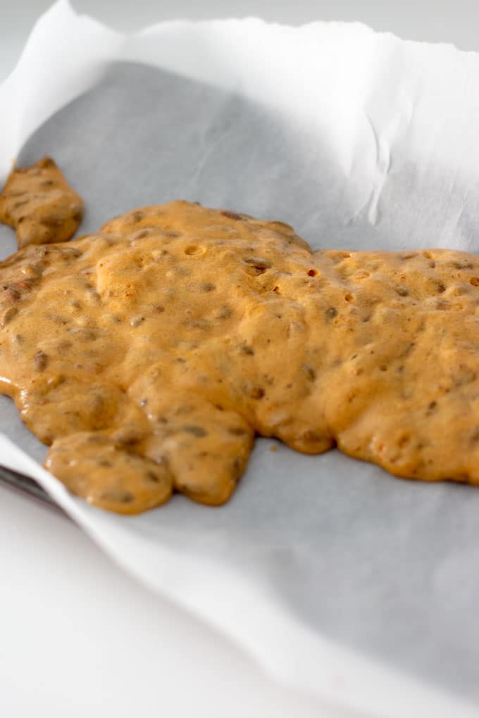 pumpkin seed brittle poured on parchment paper
