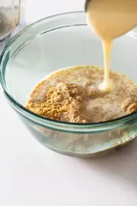 Condensed milk being poured into bowl of ingredients