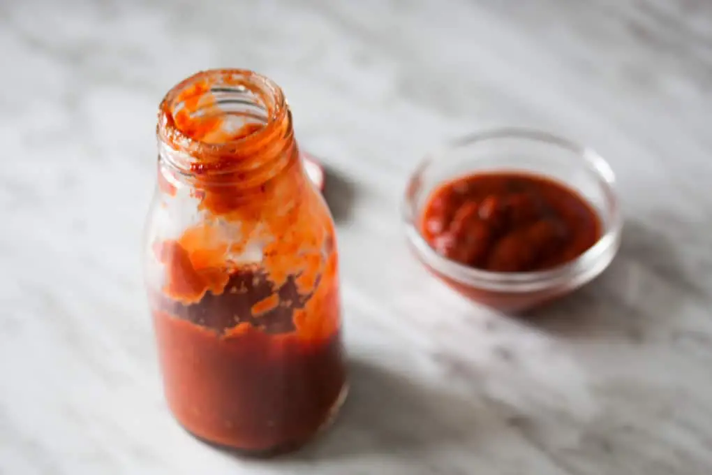 Homemade ketchup in bottle and bowl