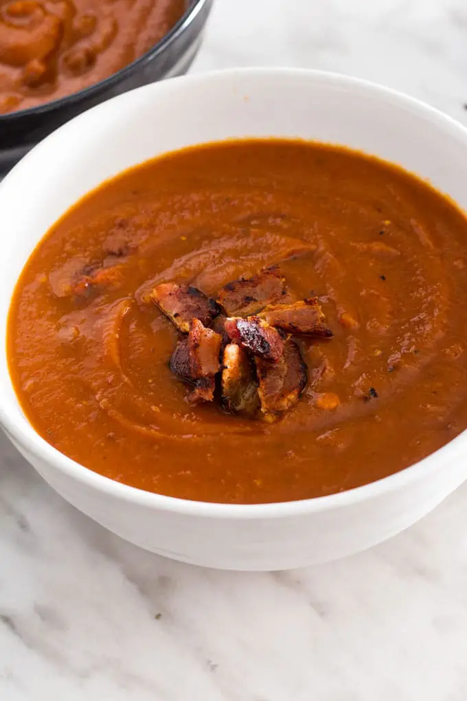 soup topped with bacon served in white bowl