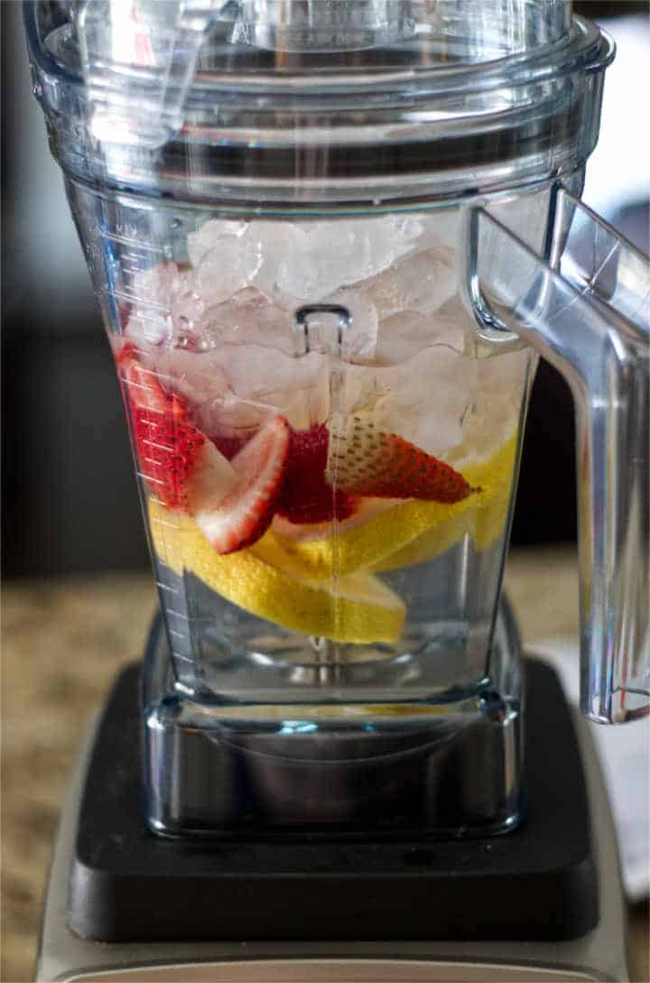 Blender Jar with ice, strawberries and lemon slices
