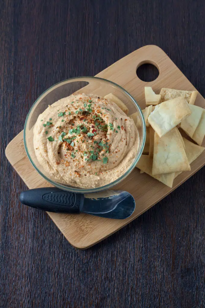 hummus served on cutting board with pita chips